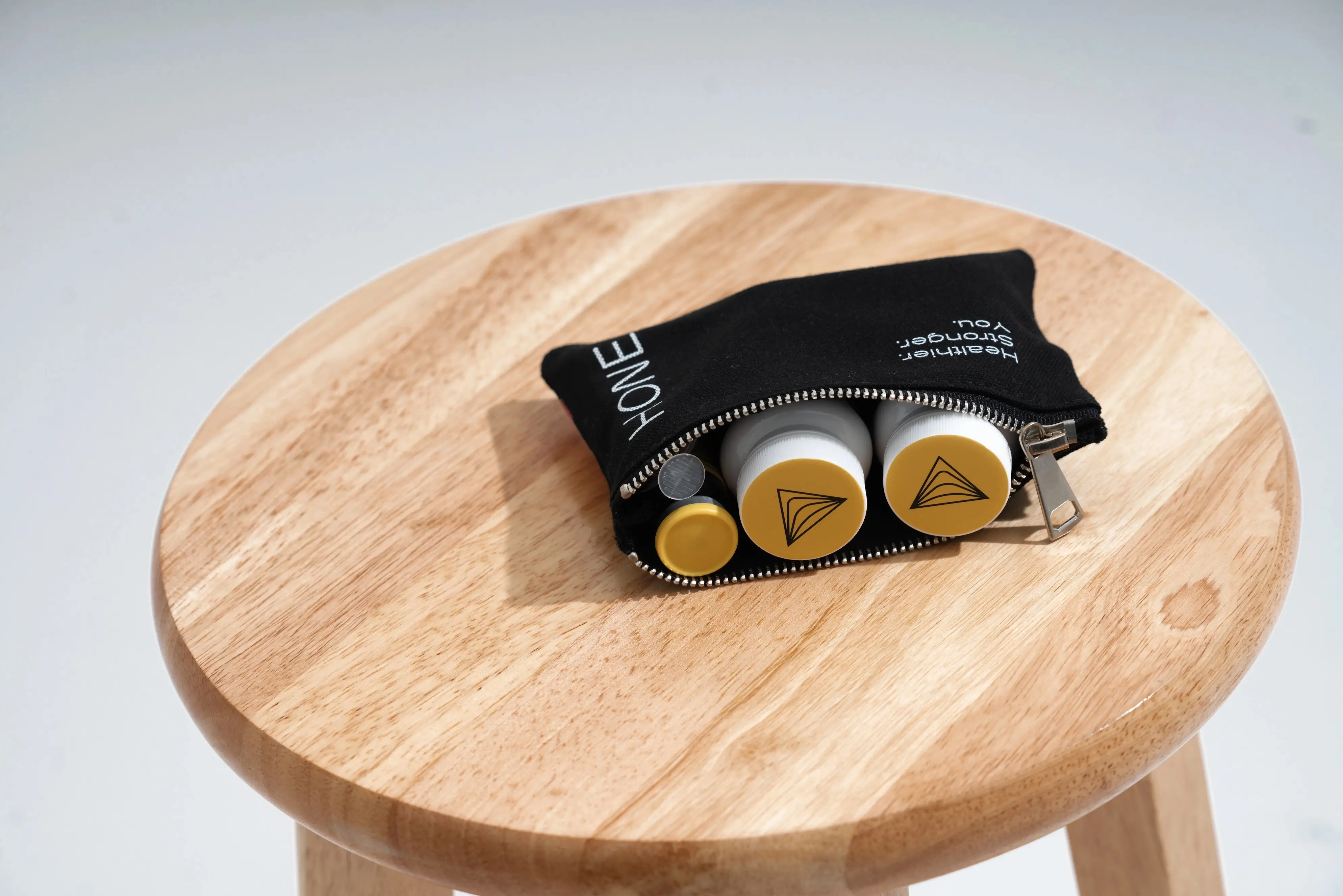 An unzipped Hone pouch showing multiple Hone health products inside.